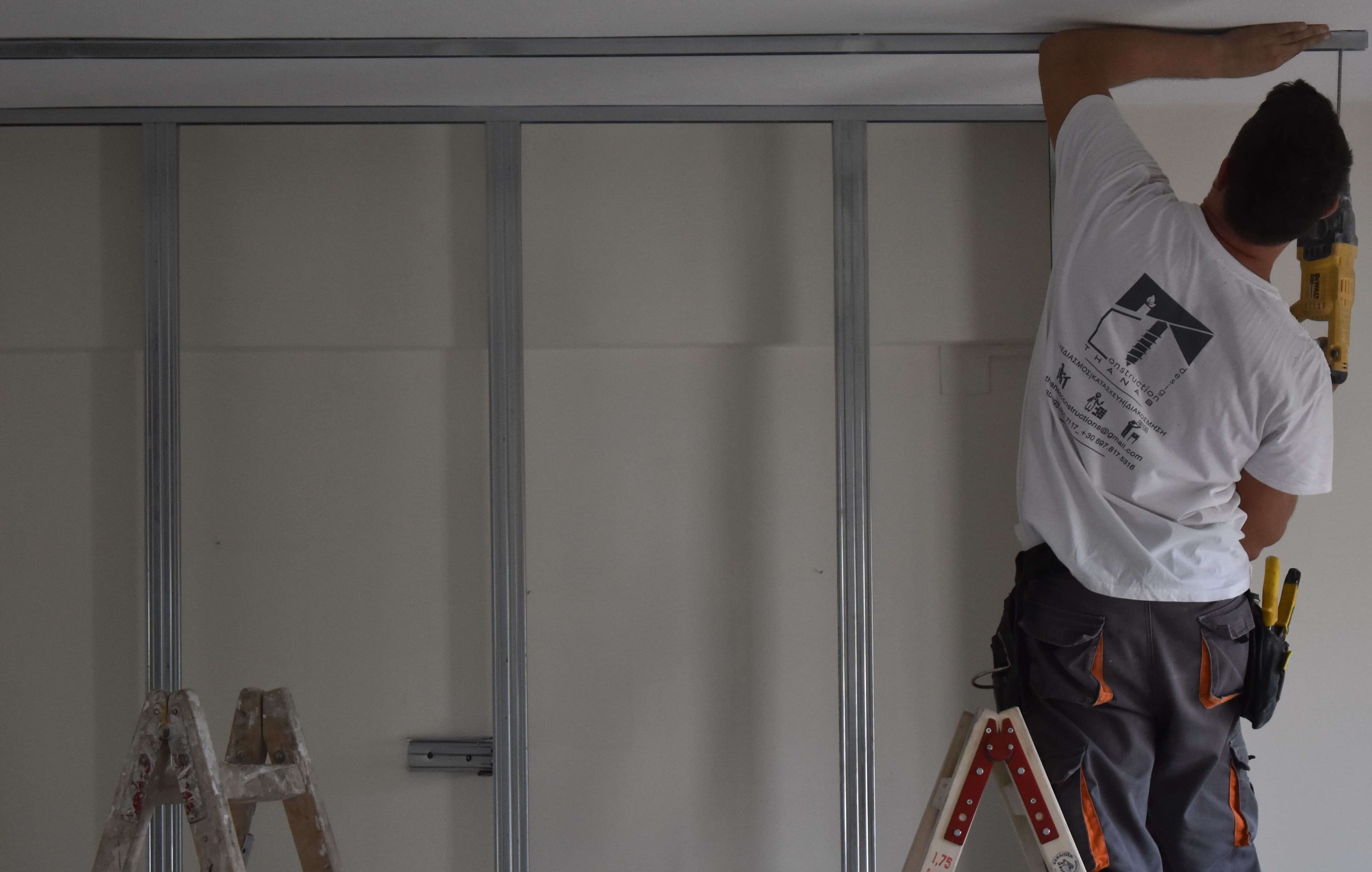 Construction worker installing drywall